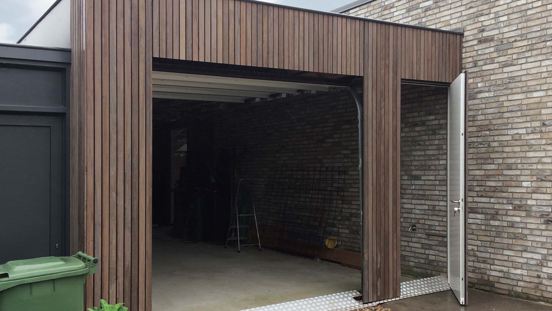 Verticale plato garagedeur gelijk in de gevel met loopdeur - Different Doors